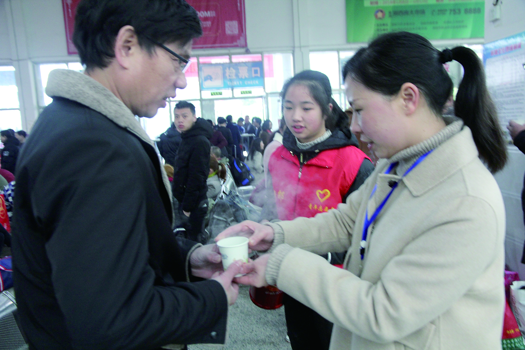 母女服務(wù)春運(yùn) 2月13日，記者在新邵分公司汽車站看到，該分公司安全科副科長(zhǎng)李喜梅與其在新邵一中初中部1701班就讀女兒劉嘉怡在車站擔(dān)當(dāng)志愿者。李喜梅在候車室耐心為旅客釋疑解惑，劉嘉怡為旅客遞上一杯杯熱茶，有時(shí)母女也相互合作，其樂融融。 祖冠 攝影報(bào)道
